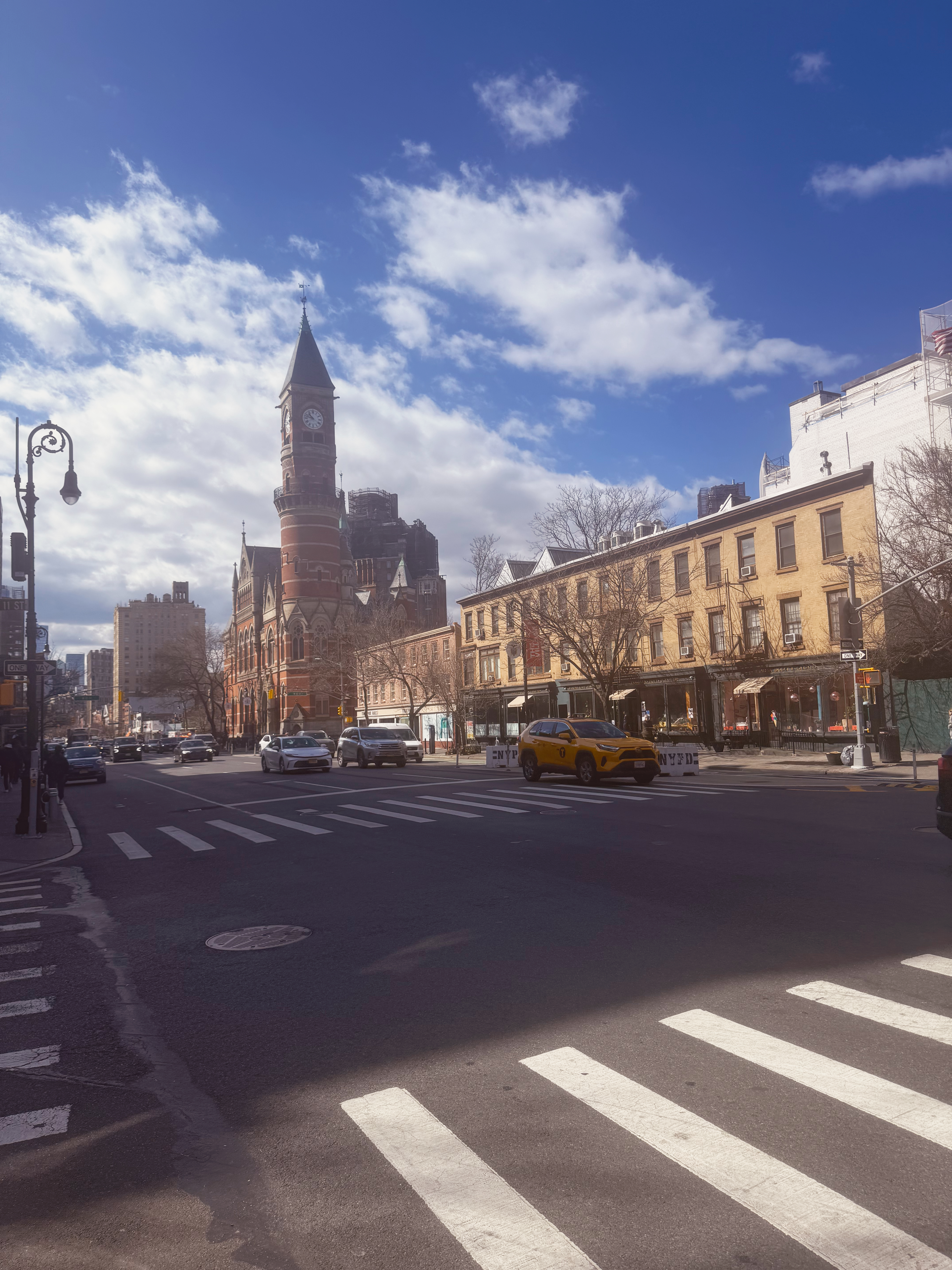 NYC street with a clock tower, taxi, architecture, and crosswalk